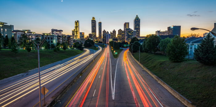 Light trails of vehicles on a road leading to the city.